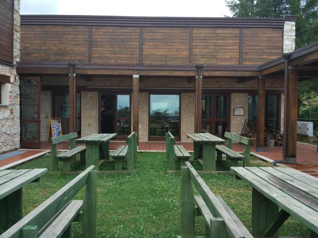 un grupo de bancos de picnic frente a un edificio en Rifugio Garulla en Amandola