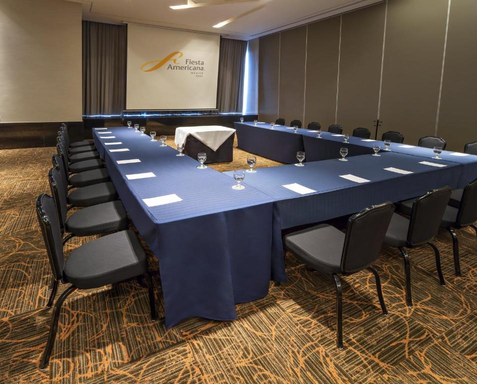 A formal meeting room arranged in a U-shaped conference layout.