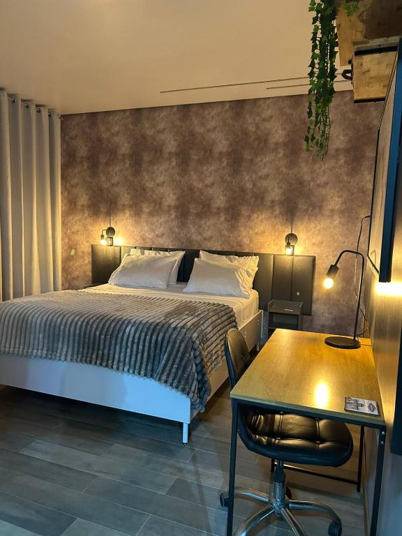 a bedroom with a bed and a table and a desk at Studio com piscina e garagem Conforto e fácil acesso BR-101-Petfriendly, 2º andar in Joinville