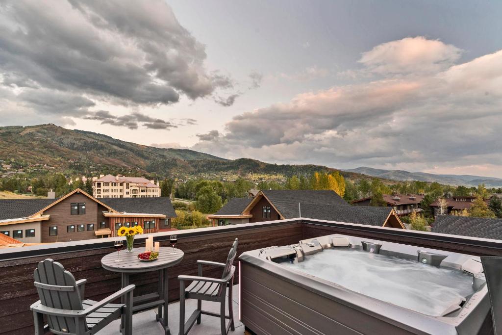 a hot tub on a balcony with a table and chairs at Metropolitan House in Steamboat Springs