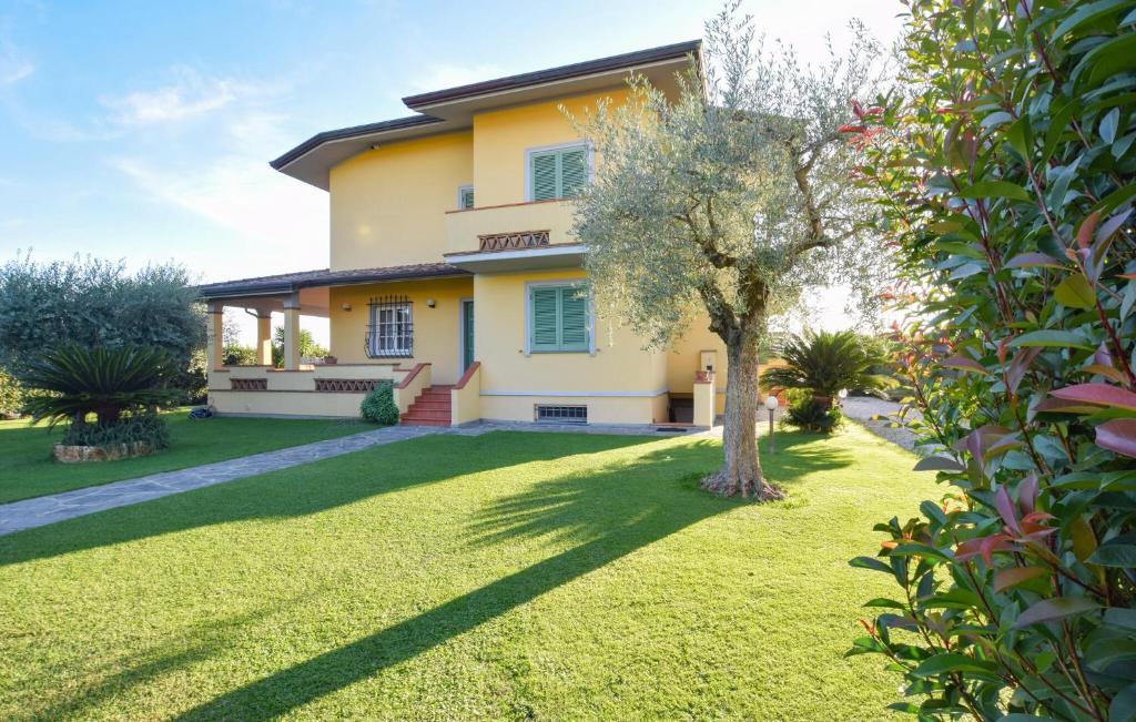 a large yellow house with a tree in the yard at Beautiful Home In Capezzano Pianore in Capezzano Pianore,