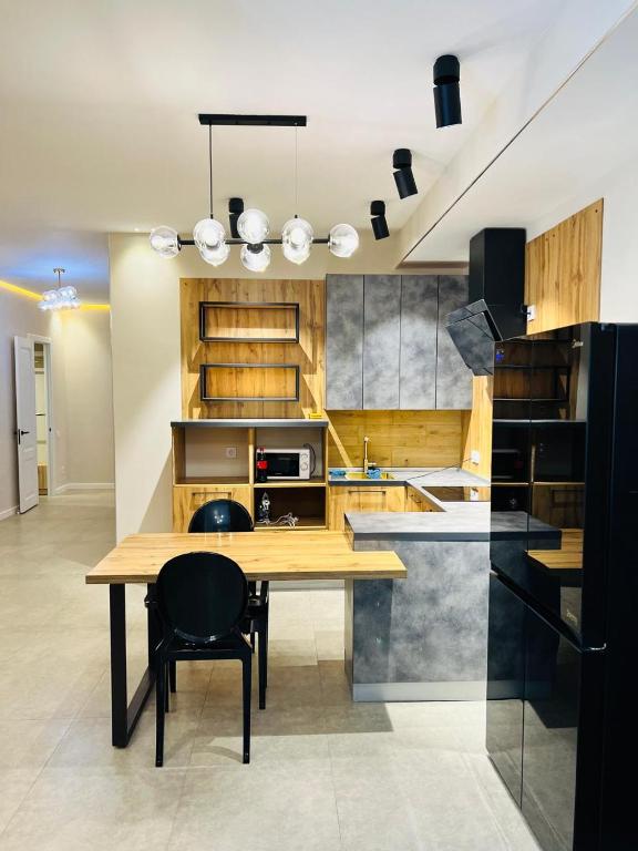 a kitchen with a wooden table and a black chair at Квартира 17-23 in Aktau