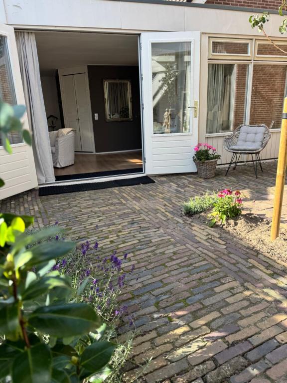 Un patio con un camino de piedra que conduce a una casa. en De kleine Bongerd -The little Orchard, en Hengelo