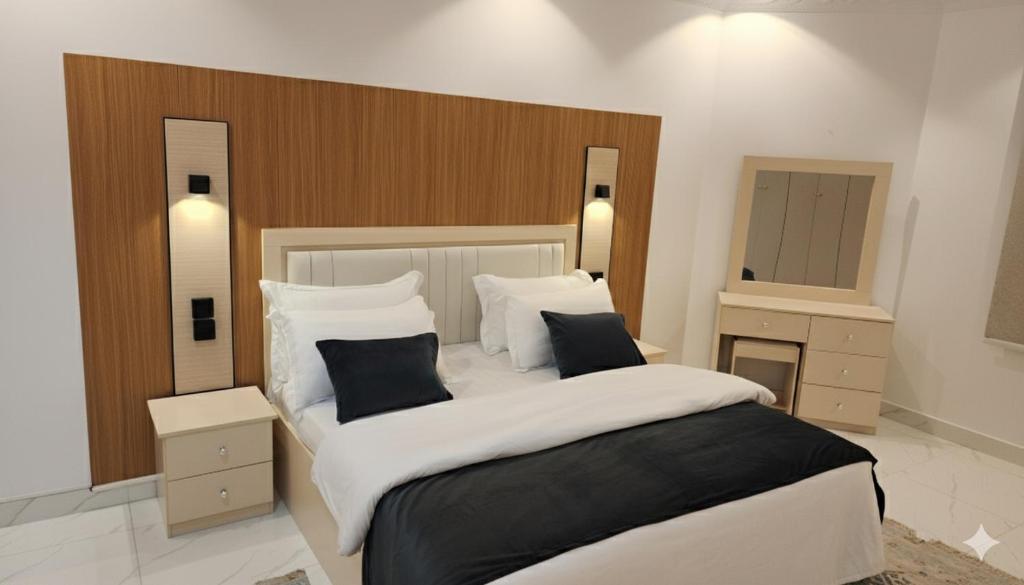 a bedroom with a large bed with two pillows at شقق الفخامة in Al Madinah