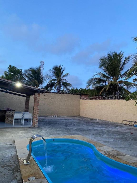 a swimming pool with a fountain in a yard at Casa Brisas in Luis Correia