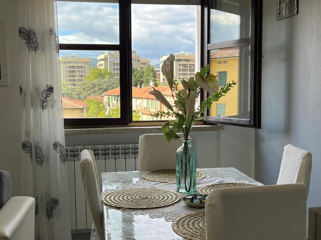 una mesa de comedor con un jarrón con flores. en Casa BELLOCCHIO, en Perugia