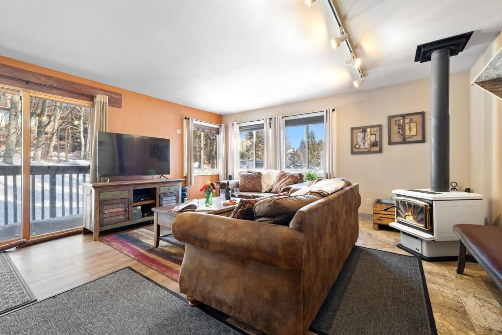 a living room with a couch and a television at RMR: Sleeping Indian West 1 Condo in Teton Village in Teton Village