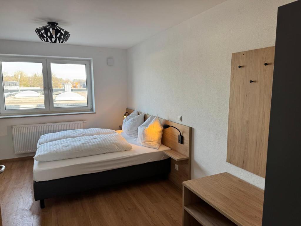 a bedroom with a bed and a window at Gästehaus Paartal in Schrobenhausen