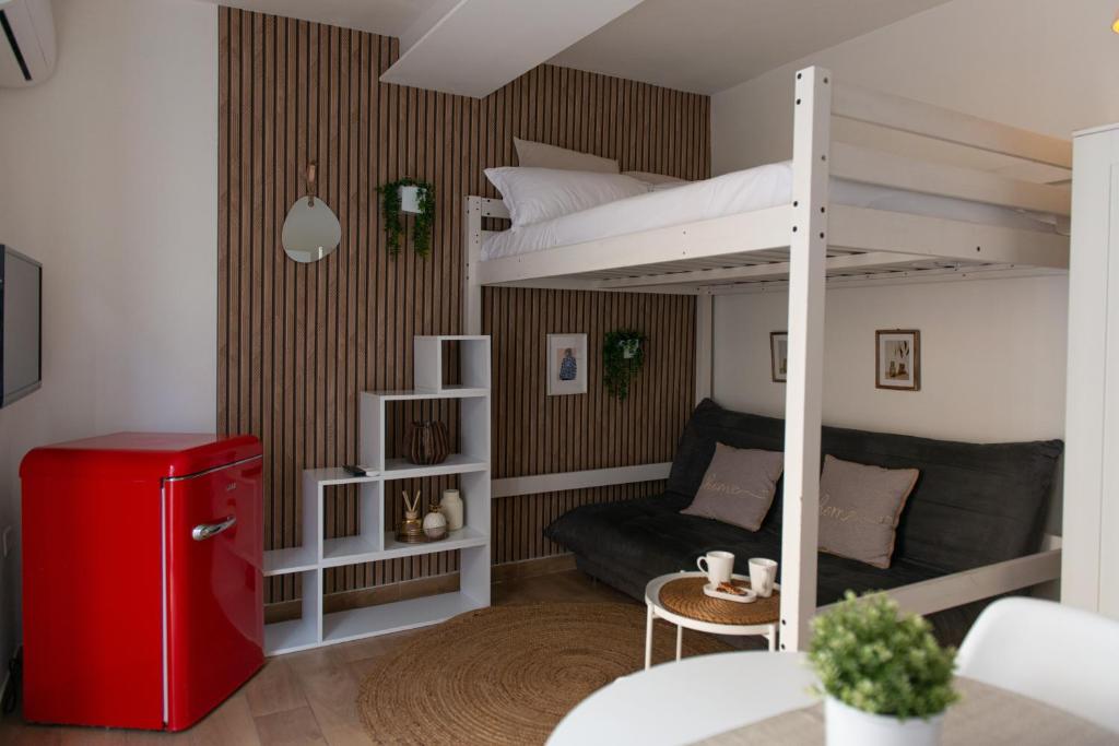 a small room with a bunk bed and a red refrigerator at Lætitia Cottage Apartment in Aversa