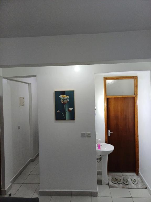 a bathroom with a flower in a picture on the wall at Lavish 2 Bedroom in Mombasa CBD in Mombasa