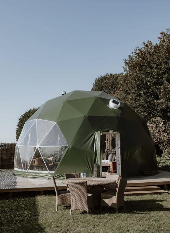 a tent on a table with two chairs under it at Star Gazing Dome 3 with Log Burner & Optional Hot tub in Horspath