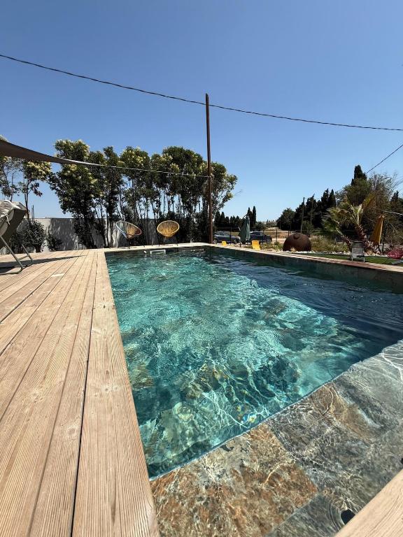 a swimming pool with a wooden deck at Villa d'exception à Mauguio Piscine chauffée in Mauguio