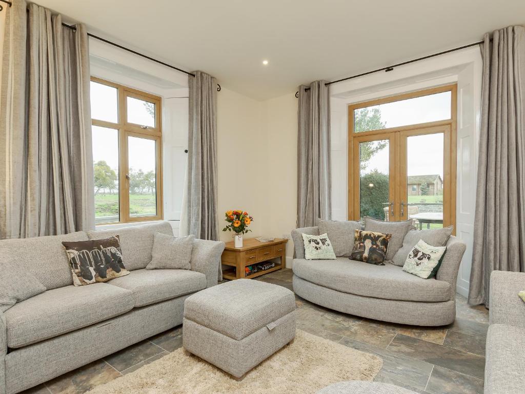 a living room with two couches and a table at The Farmhouse - Uk10655 in West Pennard