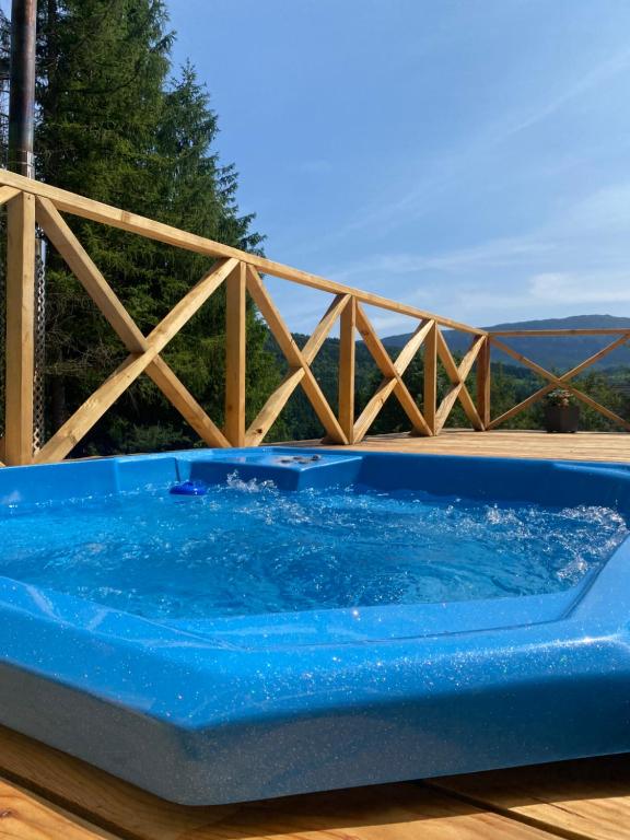 una vasca blu seduta sopra un ponte di legno di Brda 5 osobowa z jacuzzi a Zawoja