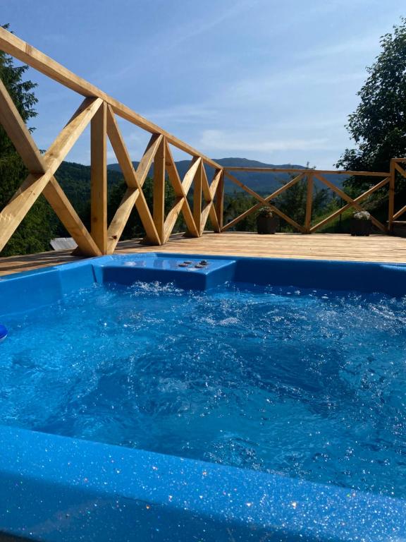 a blue swimming pool with a wooden fence at Brda 5 osobowa z jacuzzi in Zawoja