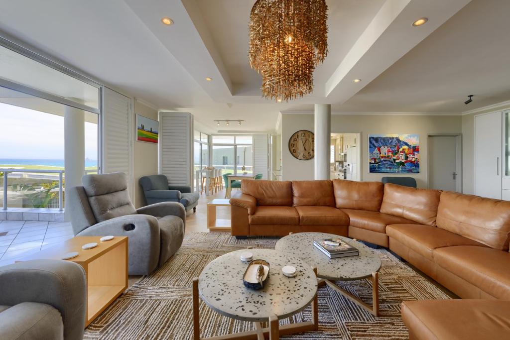 a living room with a couch and a table at Dolphin beach Apartment -Kite beach in Cape Town