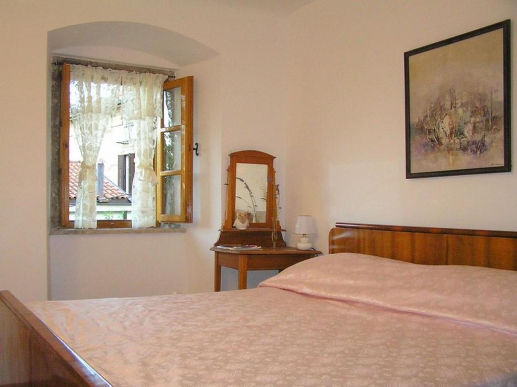 sypialnia z łóżkiem, lustrem i oknem w obiekcie Apartments Camellia & Magnolia w mieście Volosko