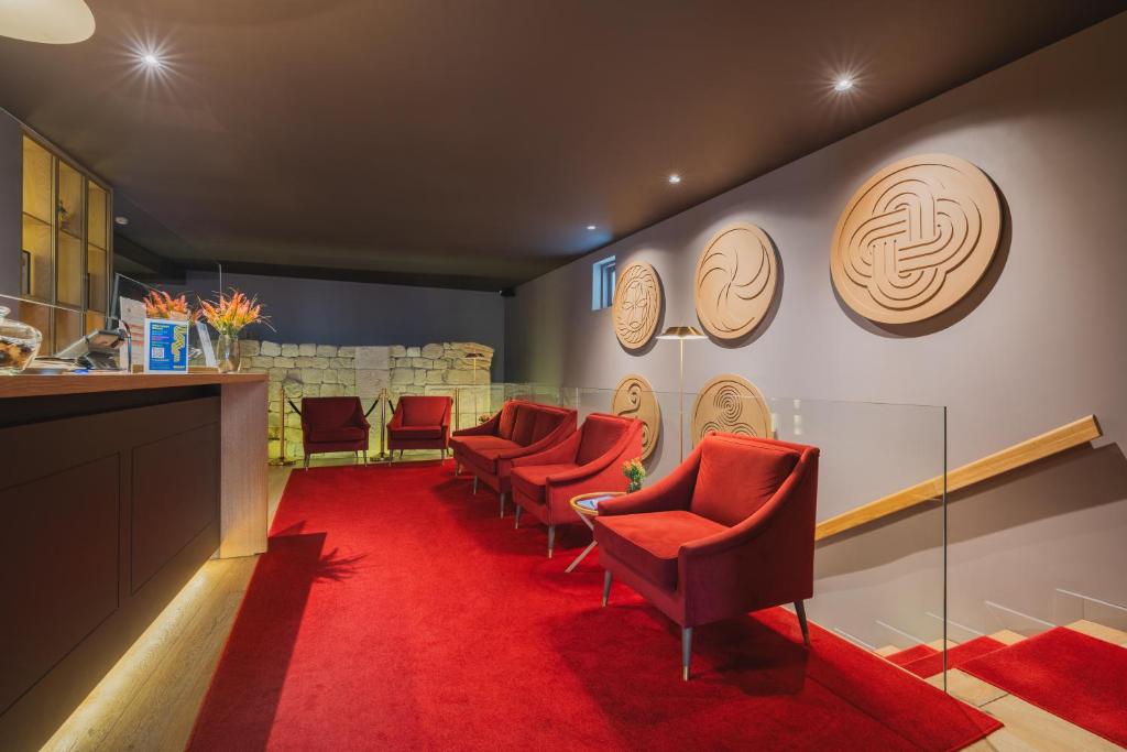 a waiting room with red chairs and a red carpet at Burgus Tribute & Design Hotel in Braga