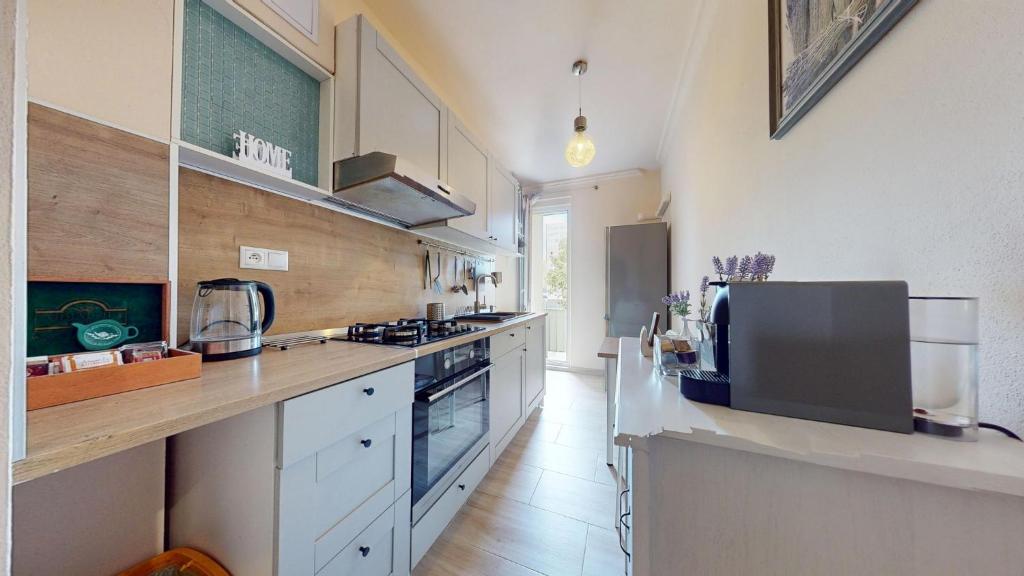 a large kitchen with white cabinets and a counter top at Senza apartment in Bratislava