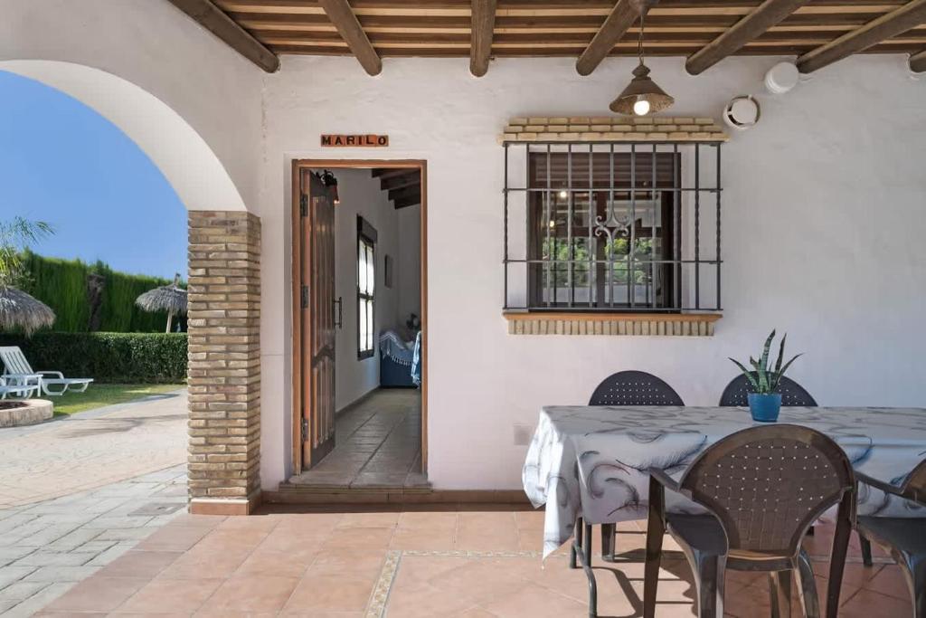 a patio with a table and chairs in front of a house at Casa rural con piscina compartida y WIFI in Roche