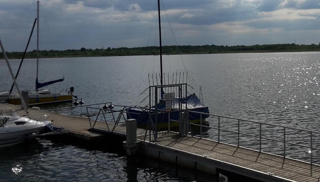 Ein Boot liegt an einem Dock auf einem See. in der Unterkunft Ferienwohnung Markkleeberg Ost-See in Markkleeberg
