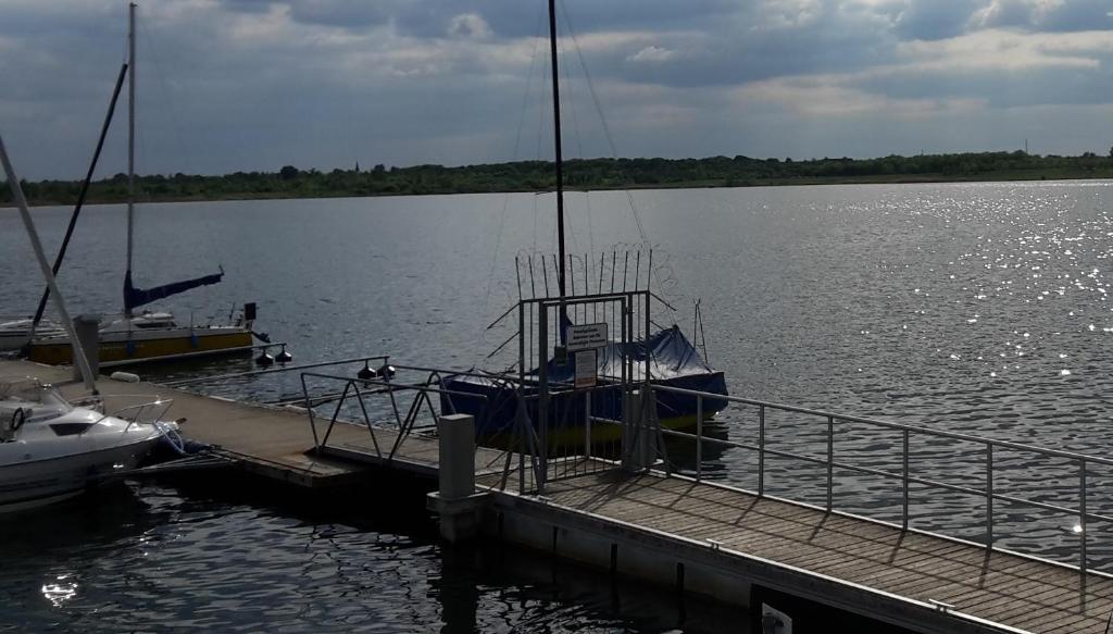 a boat is docked at a dock on a lake at Ferienwohnung Markkleeberg Ost-See in Markkleeberg