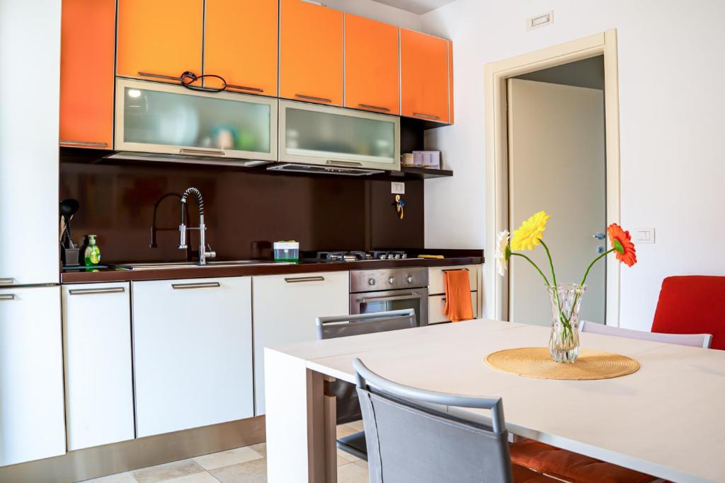 a kitchen with a table with a vase of flowers on it at La casa di Leonardo in Civitanova Marche