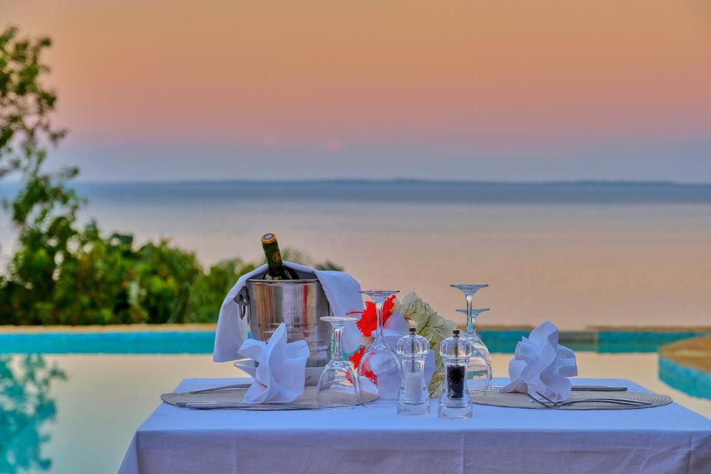 a table with a bottle of wine and glasses at Manja Kely Lodge - Nosy Komba Island in Nosy Be