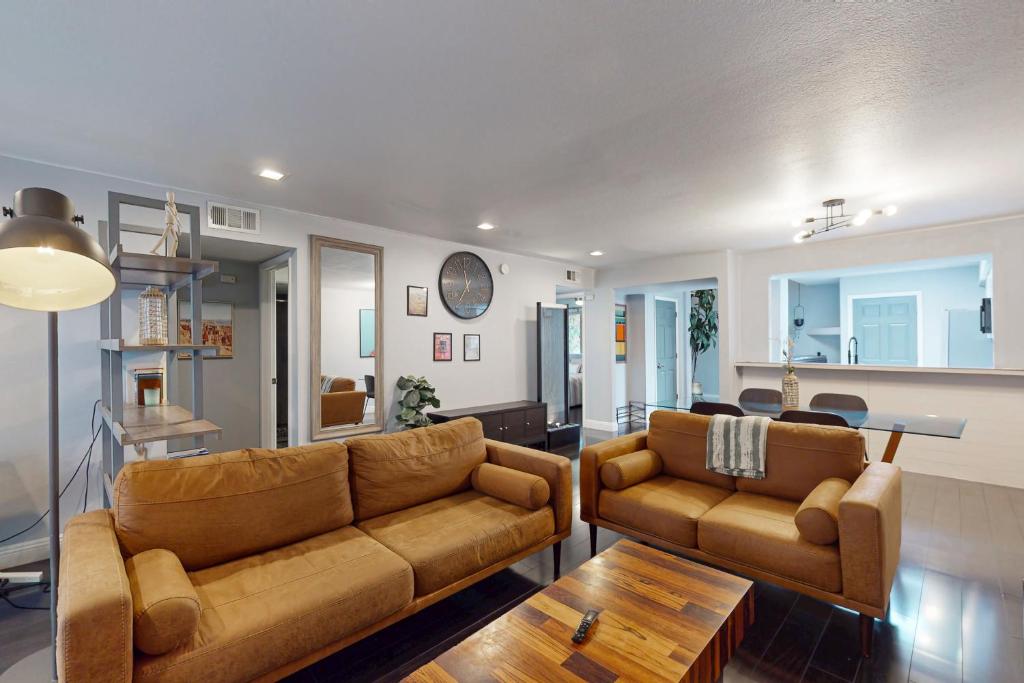 a living room with two brown couches and a table at The Gardens Getaway in Tempe