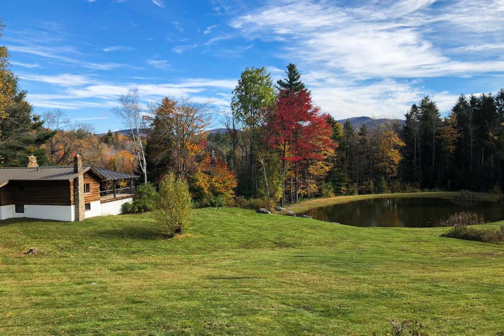 a house in a field next to a lake at Parker Lane Cabin in Weston