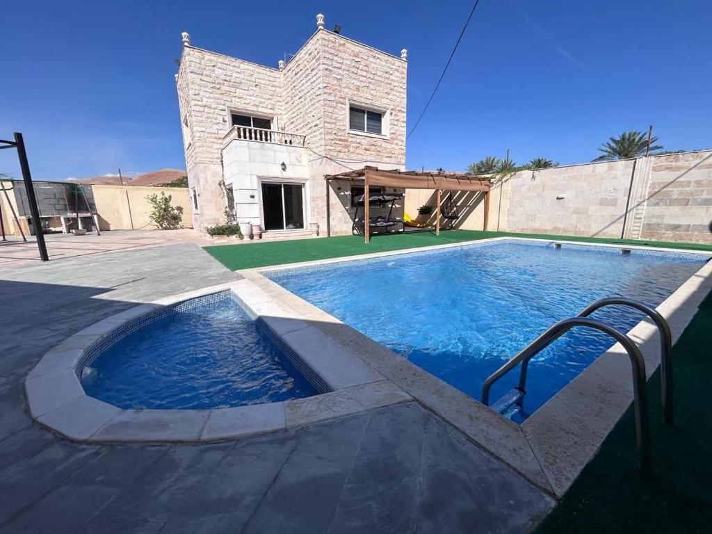 una gran piscina frente a una casa en Nay's Chalet, en Shūnat Nimrīn