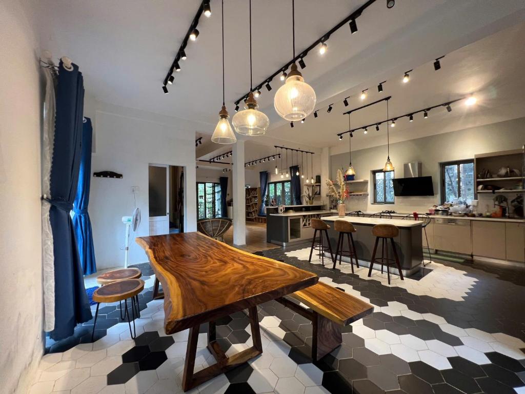 eine Küche und ein Wohnzimmer mit einem Holztisch in der Unterkunft Dốc mộng mơ homestay & villa in Chương Nghĩa