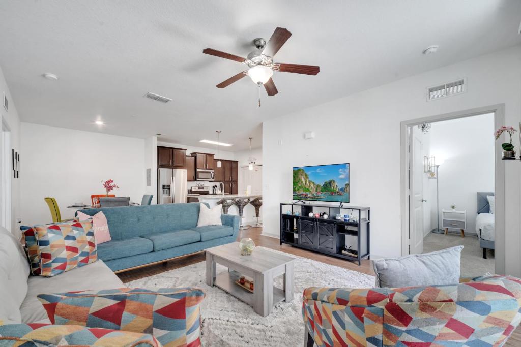 a living room with a blue couch and a ceiling fan at Stay at Universal Studios - Epic Area in Orlando