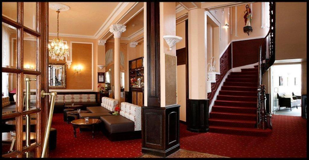 a lobby with a staircase in a building at Hôtel Métropole in Lourdes