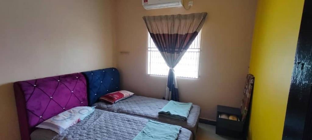 a small bedroom with a bed and a window at Homestay Hajah Jamilah Sungai Tiram 04 in Ulu Tiram