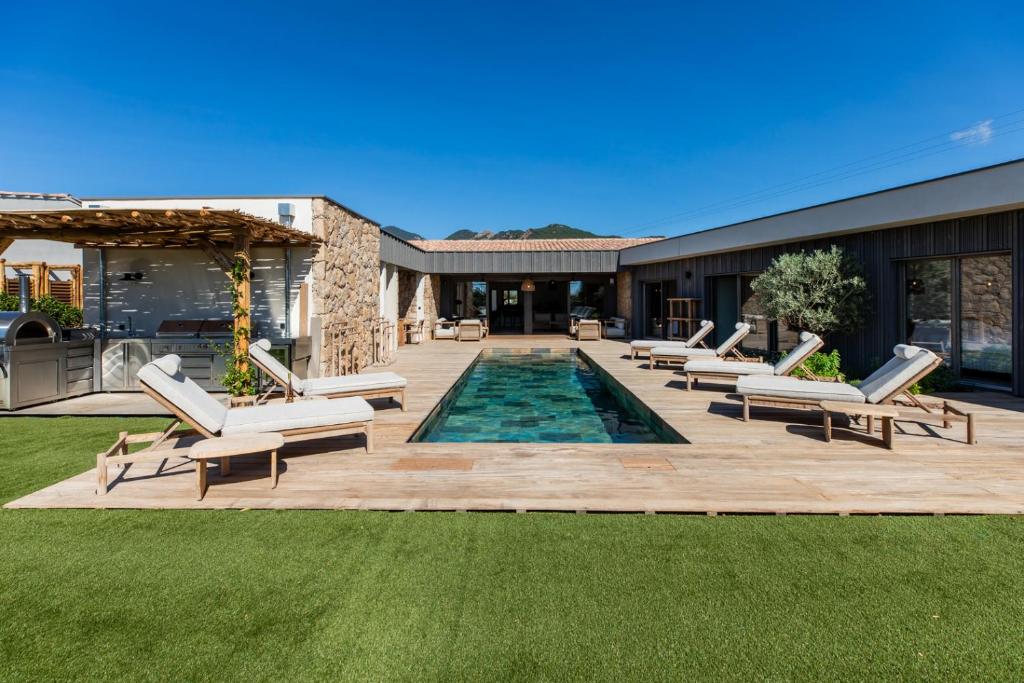 eine Terrasse mit Liegestühlen und ein Swimmingpool in der Unterkunft luxury villa les Kiks 5 chambres, piscine chauffée, Lecci in Lecci