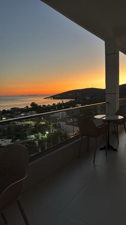 a balcony with a view of the ocean at sunset at Vila Alexandros in Qeparo