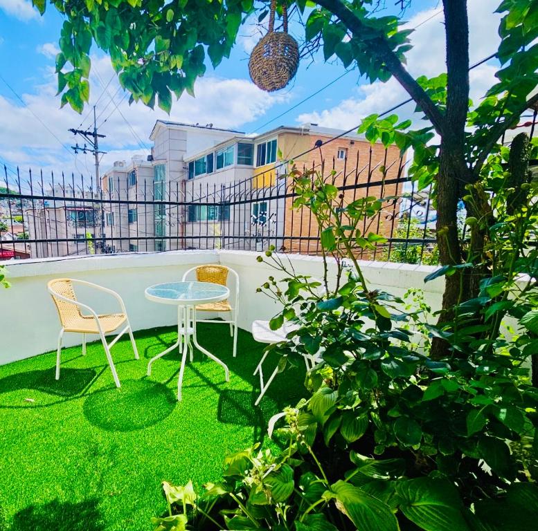 a patio with two chairs and a table on the grass at 후암가옥 in Seoul
