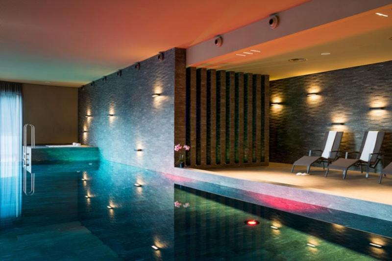 a swimming pool in a hotel with a bath tub at AVO 2 room wellness apartment in Laax