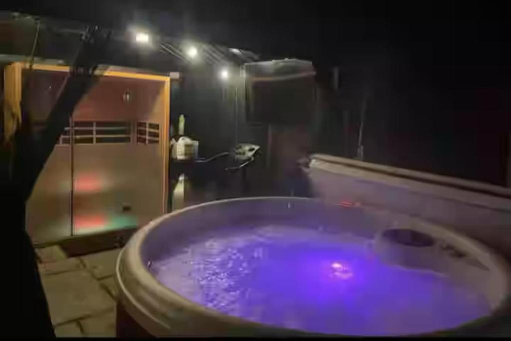 une salle de bain avec une baignoire violette avec douche dans l'établissement Pet Friendly Home in Chelmsford-Hot Tub-Sleeps 6, à Latchingdon and Snoreham