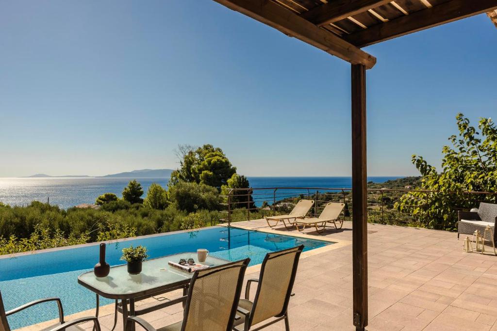 a patio with a table and chairs next to a swimming pool at Spartia Bay Cottage by Vintage Travel in Spartia