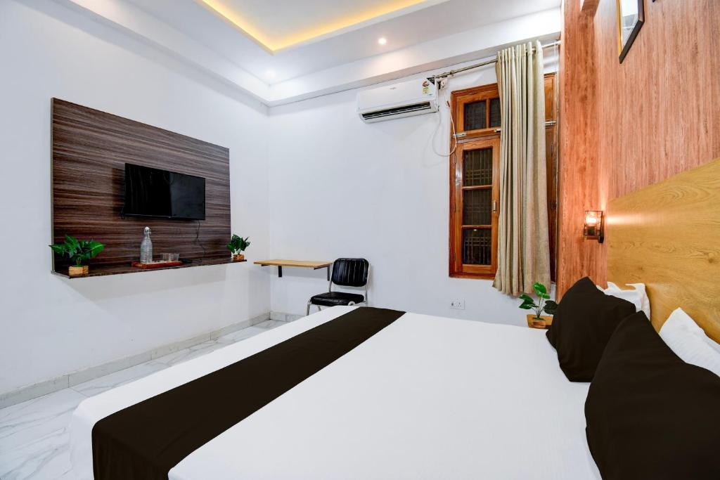 ラクナウにあるHotel O VELMORA HOTELのベッドとテレビのある寝室