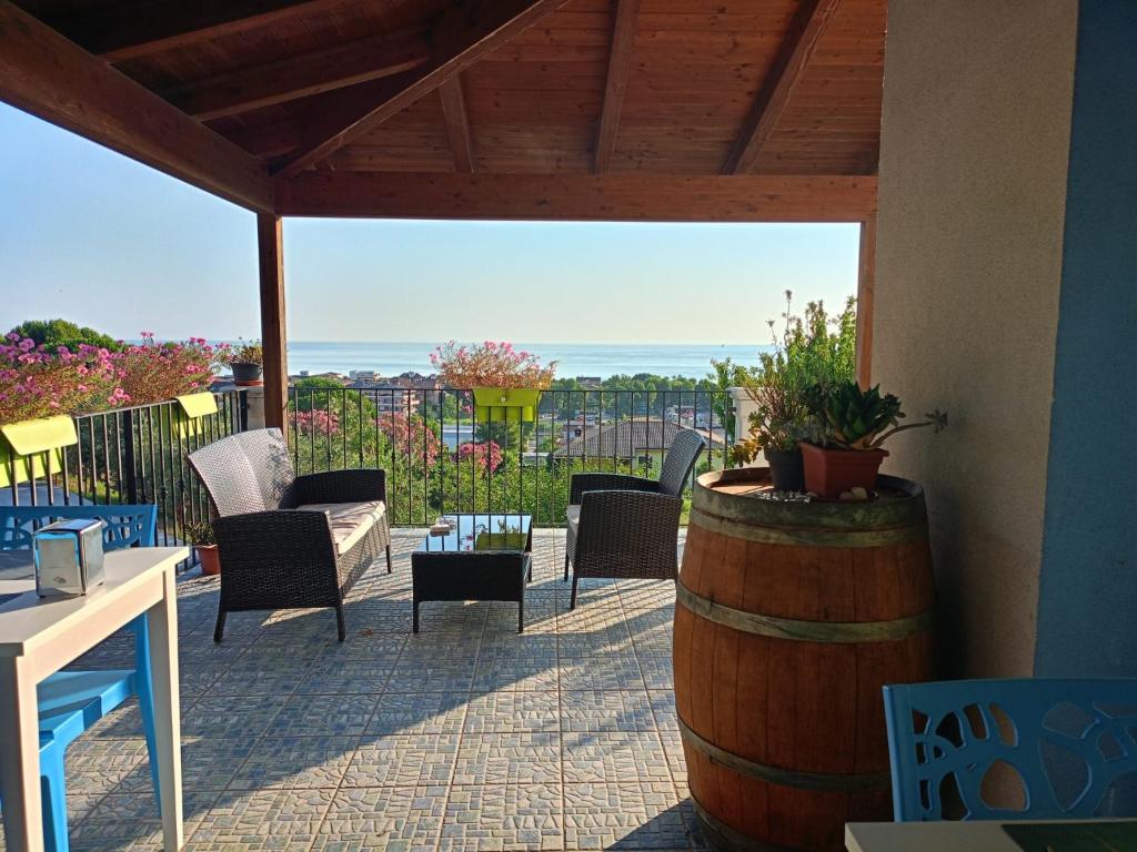 a patio with chairs and a table and a barrel at B&B Villamarea in Francavilla al Mare