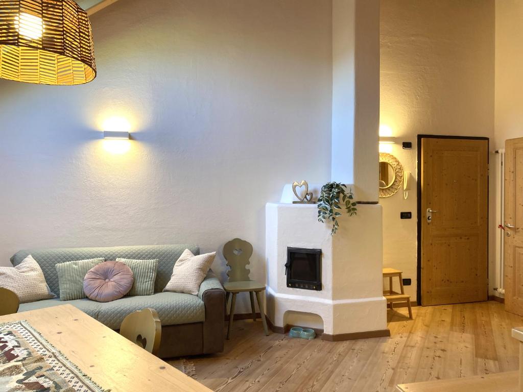 Mansarda Ai Tigli في كاستيلو-مولينا دي فيم: غرفة معيشة مع أريكة ومدفأة