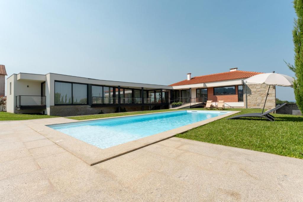 a swimming pool in front of a house at Casa do Avô in Viana do Castelo