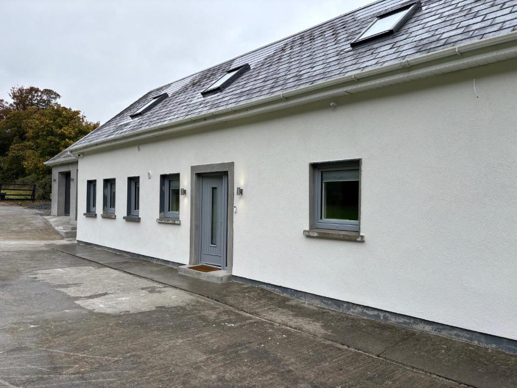 a white building with a blue door and windows at The Overlook in Cahir