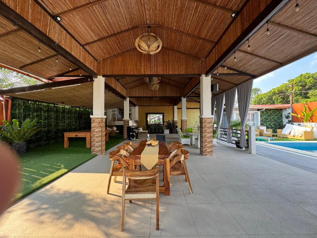 a patio with a table and chairs under a wooden ceiling at Villa Valber in Aga