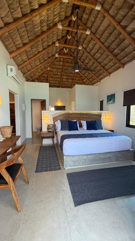 a bedroom with a large bed and a wooden ceiling at Azul Beach Kite Resort in El Sargento