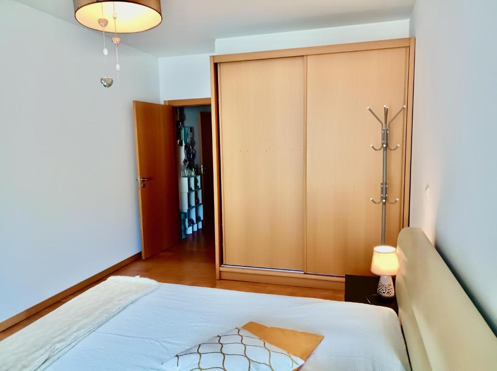 a bedroom with a bed and a closet at Sunny Little Sister Apartment - 7 min walking from the sea in Machico