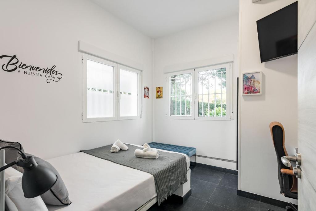 a bedroom with a bed and a tv and windows at Charming Madrid Las Rosas, Alojamiento de 2 habitaciones con cocina in Madrid